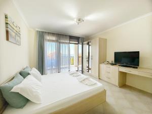 a bedroom with a large bed and a television at Studio Sun Marina in Sozopol