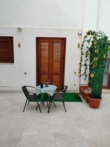 a patio with a table and chairs and a potted plant at casa vacanze pupo 2.0 in Favignana