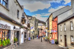 a street in an old town with people walking down the street at Carlingford Glamping Hut in Rathcor Lower