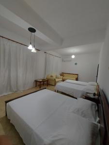 a hotel room with two beds and a couch at Guest House Irvin in Berat