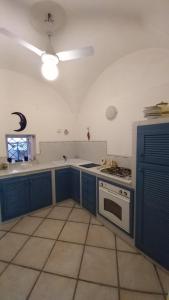 La cuisine est équipée de placards bleus et d'un four avec plaques de cuisson. dans l'établissement Casa MAFALDA, à Gaète