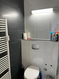 La salle de bains est pourvue de toilettes blanches et d'une lampe. dans l'établissement Stylish Apartment in Friesenplatz, Heart of Cologne, à Cologne