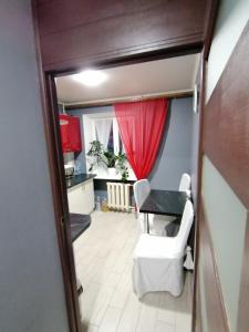 尼古拉耶夫Квартира的一间设有桌子和红色窗帘的房间