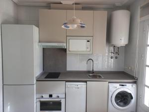 een keuken met een wasmachine en een wasmachine bij Apartamento La Barrosa - Chiclana - Urb. Pinar Atlántico in Chiclana de la Frontera