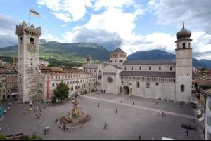 a large building with a clock tower and a fountain at B&B and Apartments Al Duomo in Trento