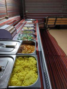 eine Reihe von Tabletts mit Speisen am Buffet in der Unterkunft bedouin city camp in Wadi Rum