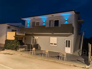 a house with two chairs and blue lights on it at Apartments Dado in Baška Voda