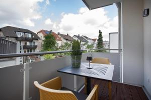 a balcony with a table and chairs and a window at Apartmenthaus am Kaiser-Wilhelm-Park in Detmold