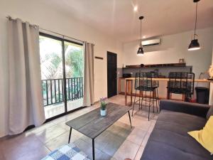 a living room with a couch and a table at Riverside Apartments - Walk to the Beach in Santa Teresa! Newly Renovated! in Santa Teresa Beach