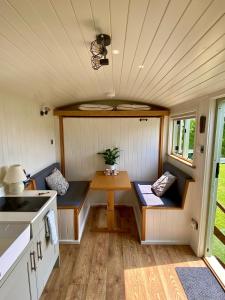 una pequeña cocina con mesa en una casa pequeña en Shepherds Hut, Conwy Valley, en Conwy
