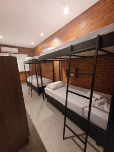 2 łóżka piętrowe w pokoju z ceglaną ścianą w obiekcie Bee Cool Hostel w mieście Palmas