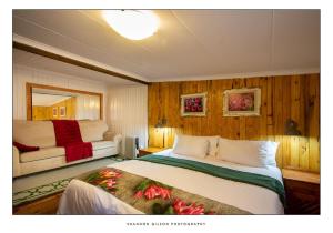 a hotel room with a bed and a couch at JoyWood Cottages in Himeville