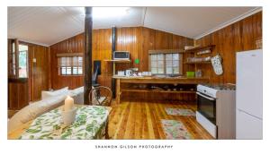 a kitchen with wooden walls and wooden flooring at Stunning Cosy cottages close to SaniPass mountains with Wifi and Dstv in Himeville