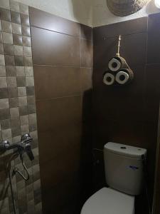 a bathroom with a toilet with a fan on the wall at Chiwash Place Taghazout in Taghazout