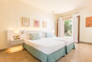 Hotel Sa Franquesa Nova في فيافرانكا دي بوناني: غرفة نوم مع سرير أبيض كبير مع نافذة