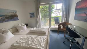 a room with two beds and a desk and a window at Arkonablick 53 in Juliusruh