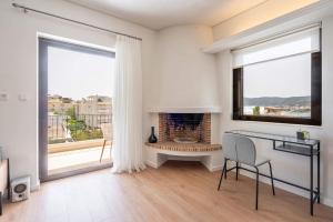 a white living room with a fireplace and a large window at M13-Sea View in Porto Rafti