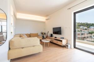 a living room with a couch and a tv at M13-Sea View in Porto Rafti