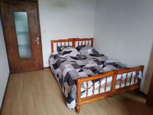 a bed with a black and white comforter in a bedroom at Sainte Eulalie source de la loire in Sainte-Eulalie
