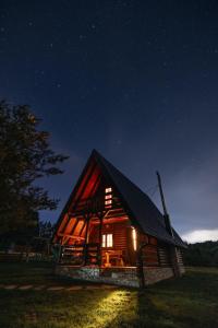 eine Blockhütte in der Nacht mit eingeschaltetem Licht in der Unterkunft Ranč Crna stina in Livno