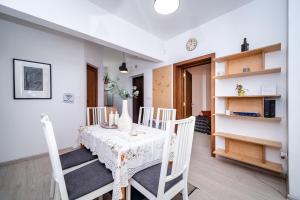 una sala da pranzo con tavolo e sedie bianchi di Bulrock Residance a Sofia