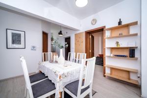 a dining room with a white table and chairs at Bulrock Residance in Sofia