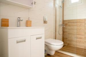 een witte badkamer met toilet en douche bij Gabi's Seabreeze Nest in Nea Kalikratia +10 foto's