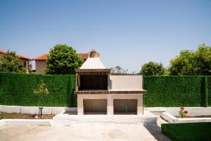 een open haard in een tuin met een haag bij Gabi's Seabreeze Nest in Nea Kalikratia