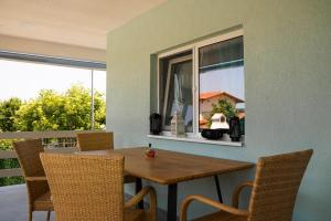 een eetkamer met een tafel en stoelen en een raam bij Gabi's Seabreeze Nest in Nea Kalikratia