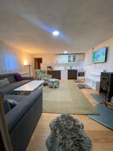 a living room with a couch and a table and a kitchen at Forest House between Sarajevo & Vlasic in Busovača