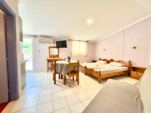 ein Wohnzimmer mit 2 Betten und einem Tisch in der Unterkunft Anemos Studios & Apartments in Póros