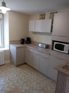 a kitchen with white cabinets and a microwave at le gite du baron in Roz-sur-Couesnon