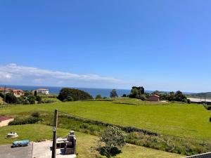 a green field with the ocean in the background at Miguelón in Bañugues