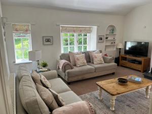 uma sala de estar com um sofá e uma mesa em Meadowcroft em Lindale