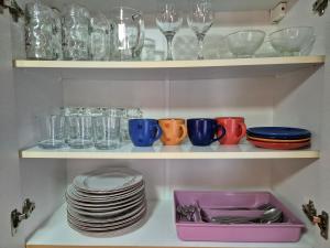 a shelf filled with plates and cups and glasses at City Center Stay in Visoko