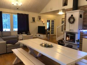 Una sala de estar con una mesa y una chimenea. en Uudehko tunnelmallinen talo, en Venesjärvi