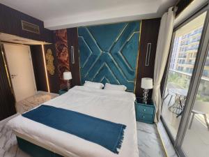 a bedroom with a large bed with a blue wall at Marjan Island Beautiful Apartment Sea View Beach Luxury Rooms Ras Al Khaimah UAE in Ras al Khaimah