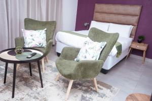 Pokój hotelowy z łóżkiem, 2 krzesłami i stołem w obiekcie Pristine Guest Apartments w mieście Mthatha