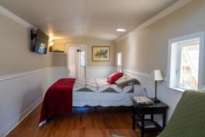 a bedroom with a bed and a table and a window at Little Red Caboose in Oakhurst
