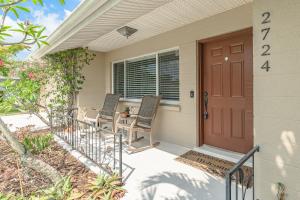 サラソタにあるClassic Tropical Florida Escape with Heated Poolの椅子2脚付きの家の玄関 +48枚の写真