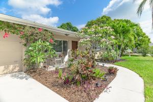 サラソタにあるClassic Tropical Florida Escape with Heated Poolの花が咲き乱れる植物と歩道のある家