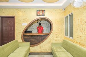 Habitación con pared y espejo redondo. en Manyata Royal Mac, en Bangalore