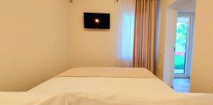un letto in una camera da letto con una televisione a parete di Merlot Apartment a Cricova