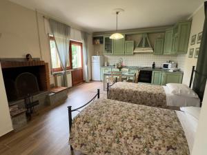 a kitchen with green cabinets and two beds in a room at I Due Ulivi in Calice al Cornoviglio