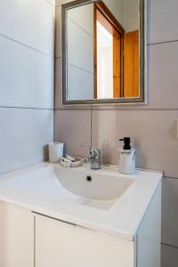 y baño con lavabo blanco y espejo. en Medousa Studio & Apartments, en Plakias