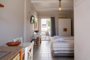 Habitación de hotel con 2 camas y mesa en Medousa Studio & Apartments, en Plakias