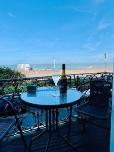 a table with a bottle of wine and a glass at "The Celebration" Balcony Seafront Apartment in Eastbourne