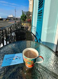 a cup of coffee sitting on top of a table at "The Celebration" Balcony Seafront Apartment in Eastbourne