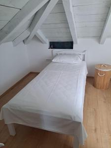 une chambre avec un lit blanc dans un grenier dans l'établissement LaLu On The Water, à Vinišće