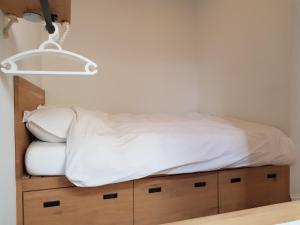 una cama con sábanas blancas y una luz sobre ella en Beach House Rodine - free parking & bikes en Scheveningen